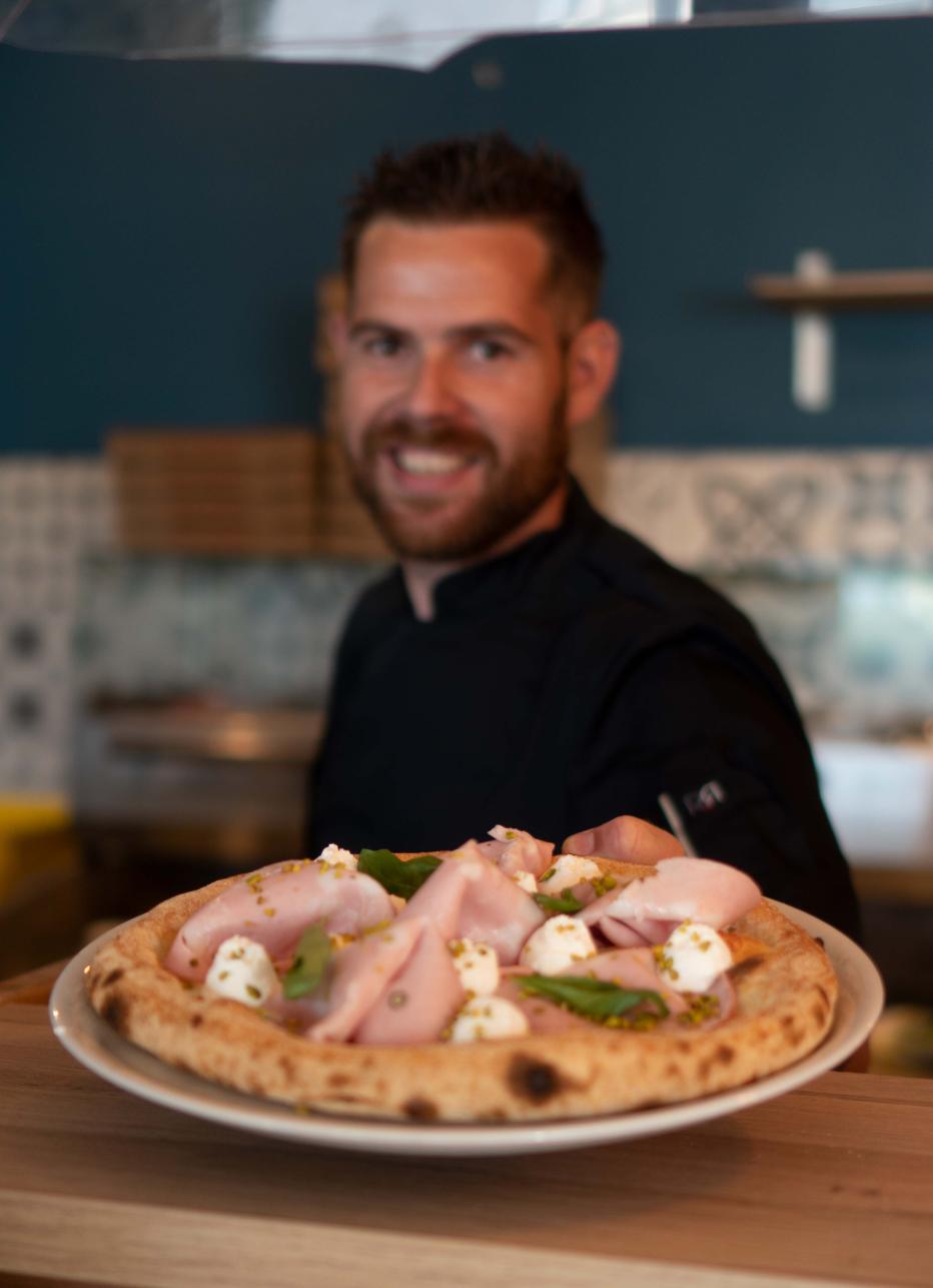 Pizza mortadelle et burrata présentée par le chef - restaurant Luma